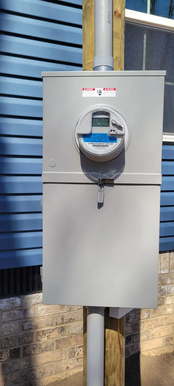 Outdoor electrical meter base and service equipment mounted beside a manufactured home.