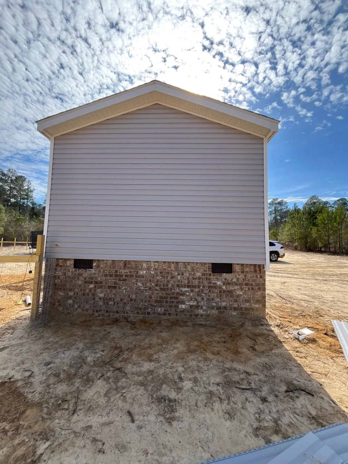 After skirting installation: brick skirting with ventilation openings around the same manufactured home.